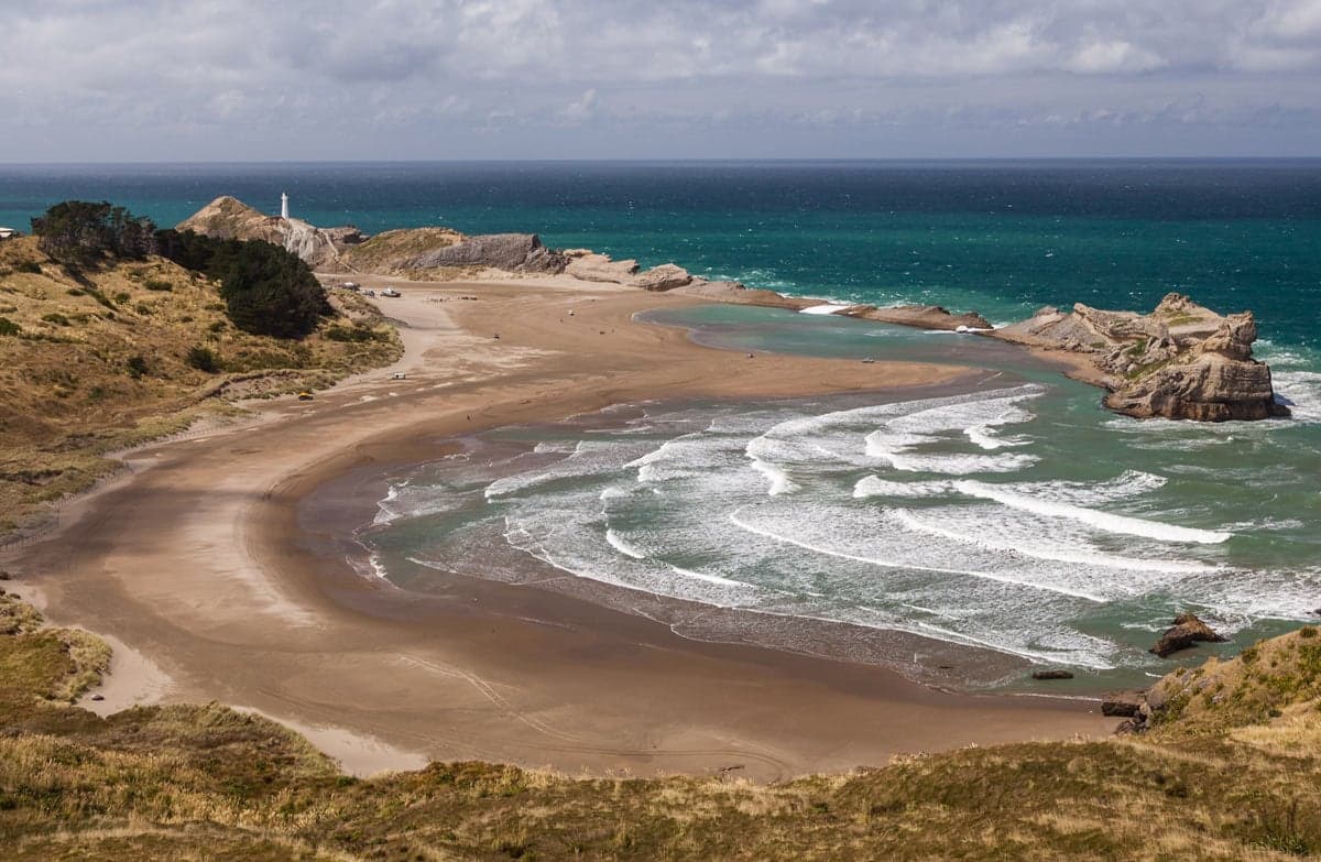 Beach with lighthouse in distance.