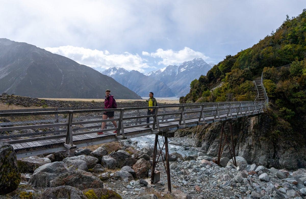 Hikers crossing a bridge on Red Tarns Track.