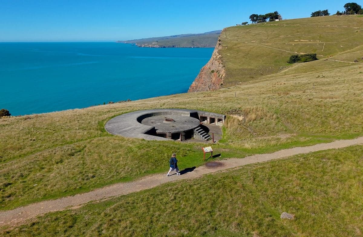 A walker approaching a clifftop gun emplacement overlooking the ocean.