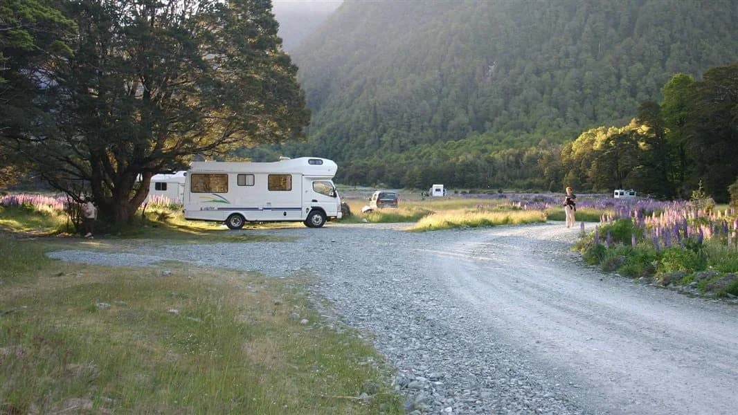 A caravan, tent and other camping vehicles beside the gravel access road at Walker Creek Campsite.